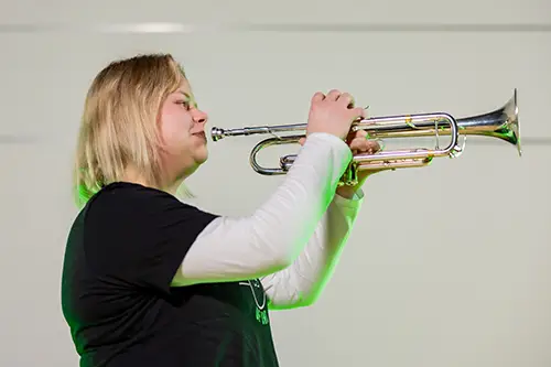 Hannah raising a trumpet, ready to play